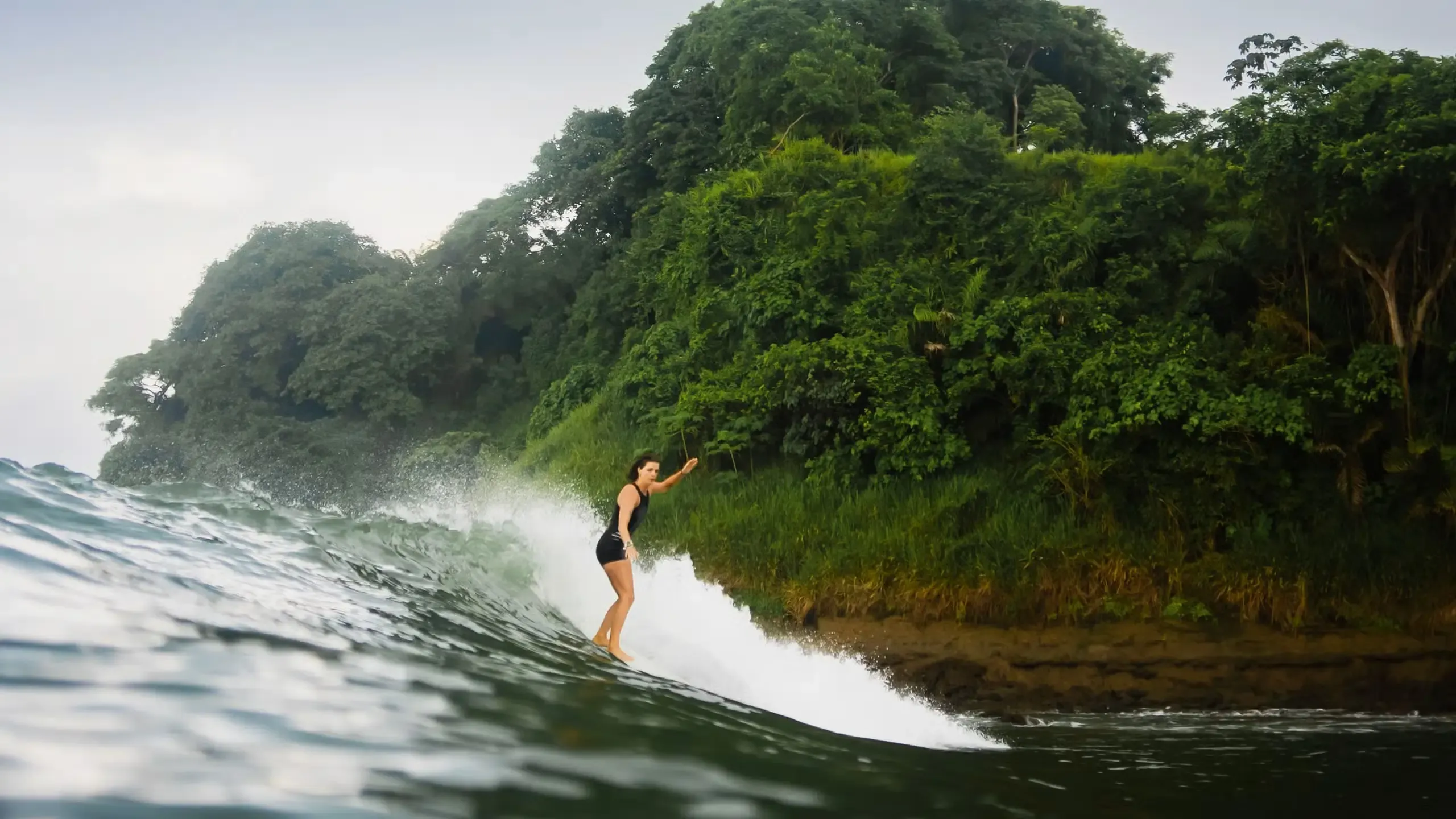 Surfer on an uncrowded point break on Ecuador's Pacific coast with an empty lineup behind