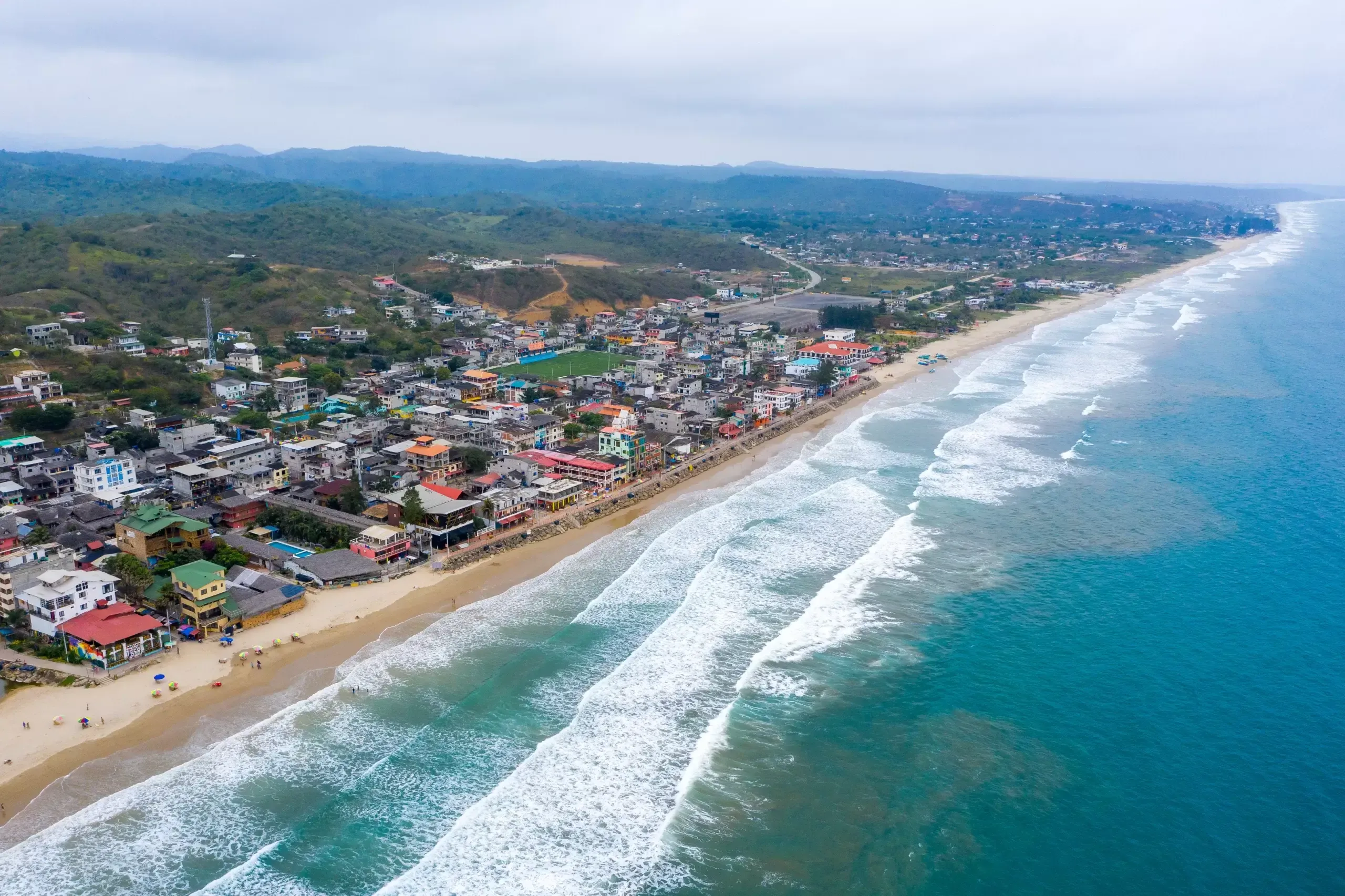 Aerial view of Montanita beach town on Ecuador's Pacific coast with palm trees and the ocean in the background